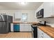 Updated kitchen features white cabinets, stainless appliances, and wood countertops at 818 Stowe Ln, Gastonia, NC 28056