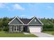 Charming home featuring stone accents, a two-car garage, and professionally landscaped front yard at 889 Exeter Dr, Sherrills Ford, NC 28673
