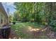 A well-maintained backyard features a lush lawn, mature trees, and partial view of the home's exterior with an HVAC unit at 9419 Olivia Ln, Charlotte, NC 28277