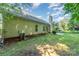 Exterior view of a home showcasing its siding, windows, chimney, lush backyard, and a concrete patio with seating at 9419 Olivia Ln, Charlotte, NC 28277