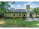 Exterior view of a home showcasing its siding, windows, chimney, lush backyard, and a concrete patio with seating at 9419 Olivia Ln, Charlotte, NC 28277