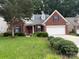 Charming single-Gathering brick home featuring a manicured lawn and two-car garage at 9419 Olivia Ln, Charlotte, NC 28277