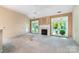 Spacious living room with a fireplace, vaulted ceiling, and access to the backyard through French doors at 9419 Olivia Ln, Charlotte, NC 28277