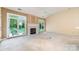 A spacious living room with a fireplace and French doors to the patio at 9419 Olivia Ln, Charlotte, NC 28277