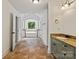 Long bathroom featuring brown tile flooring, double doors, and white walls at 1009 Jerry Ln, Matthews, NC 28105