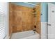 Bathroom with white tiled walls, a shower-tub combo, and a dark shower head at 1009 Jerry Ln, Matthews, NC 28105