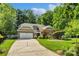 Charming home with a stone and siding exterior, attached garage, and well-manicured lawn at 1009 Jerry Ln, Matthews, NC 28105