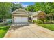 Charming home with a stone and siding exterior, attached garage, and long driveway at 1009 Jerry Ln, Matthews, NC 28105