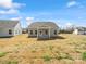 View of the back exterior of the home with four windows and a white-framed door at 1071 Bull Dog Ln, Wingate, NC 28174