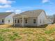 The backyard of a gray single-story home features a covered patio and lush green grass at 1071 Bull Dog Ln, Wingate, NC 28174