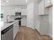 Well-lit kitchen featuring stainless appliances, white cabinets, and wood-look floors at 1074 Bull Dog Ln, Wingate, NC 28174