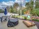 Backyard features patio, dining set, play area, lush landscaping for outdoor enjoyment at 1209 Pressley Downs Se Dr, Concord, NC 28025