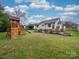 Expansive backyard with a wooden play set, offering plenty of space for outdoor fun at 1209 Pressley Downs Se Dr, Concord, NC 28025