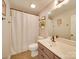 Well-lit bathroom with shower-tub combo, white vanity, and decorative shelving for added charm at 1209 Pressley Downs Se Dr, Concord, NC 28025