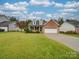 A well-maintained brick home featuring a spacious front yard, covered porch, and an attached two-car garage at 1209 Pressley Downs Se Dr, Concord, NC 28025