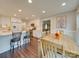 Modern kitchen with white cabinets, stainless steel appliances, and a breakfast bar overlooking dining area at 1209 Pressley Downs Se Dr, Concord, NC 28025