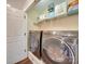 Laundry room showcasing modern, side-by-side washer and dryer units with storage above at 1209 Pressley Downs Se Dr, Concord, NC 28025