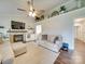 Cozy living room with a stone fireplace, ceiling fan, and stylish decor at 1209 Pressley Downs Se Dr, Concord, NC 28025