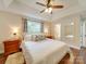 A spacious main bedroom with wood floors, a tray ceiling, and natural light at 1209 Pressley Downs Se Dr, Concord, NC 28025