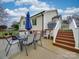 Backyard patio with outdoor dining set and stairs leading to a deck, great for entertaining at 1209 Pressley Downs Se Dr, Concord, NC 28025