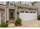 Inviting townhome featuring a welcoming front door, stone accents, and attached garage at 12205 Gambrell Dr, Charlotte, NC 28278