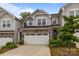 Inviting two-story townhouse with stone accents, well-manicured landscaping, and attached garage at 12205 Gambrell Dr, Charlotte, NC 28278