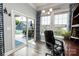 Bright home office with modern chandelier, wood floors, and sliding door access to the outdoor patio at 128 Asher Ln, Mooresville, NC 28115