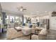Bright and open living room with a cozy sofa, large windows, and seamless kitchen access at 128 Asher Ln, Mooresville, NC 28115