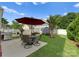 The backyard features a red umbrella, green grass, and a barbecue grill for outdoor enjoyment at 14034 Holly Springs Dr, Huntersville, NC 28078