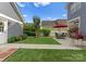 Landscaped backyard with outdoor patio, red umbrella, and well-maintained lawn at 14034 Holly Springs Dr, Huntersville, NC 28078