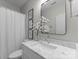 Bright and airy bathroom featuring a marble countertop and a shower curtain, designed for relaxation and comfort at 14034 Holly Springs Dr, Huntersville, NC 28078