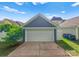 Detached garage with white door, concrete driveway, and professional landscaping at 14034 Holly Springs Dr, Huntersville, NC 28078