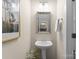 Charming powder room with pedestal sink, framed mirror, and stylish decor, offering a convenient space for guests at 14034 Holly Springs Dr, Huntersville, NC 28078