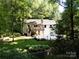 Back view of this lovely white home, featuring a deck, lush lawn and mature trees at 1408 Rinehart Ct, Charlotte, NC 28270