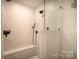 Modern bathroom with glass shower door, bench and herringbone tile at 1408 Rinehart Ct, Charlotte, NC 28270