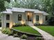 Elegant white brick home with a well-lit front entrance, and mature landscaping at 1408 Rinehart Ct, Charlotte, NC 28270