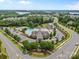 Community aerial view showcasing a pool, tennis courts, clubhouse, and lush landscaping at 14407 Cardwell Hill Ln, Charlotte, NC 28278