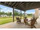 This back porch is complete with wicker furniture, a ceiling fan, and views of the fenced in yard and lake at 14407 Cardwell Hill Ln, Charlotte, NC 28278