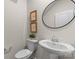 Well-lit half bathroom featuring a pedestal sink, toilet, and modern fixtures at 14407 Cardwell Hill Ln, Charlotte, NC 28278