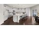 Spacious kitchen featuring white cabinets, a large island with seating, and stainless steel appliances at 14407 Cardwell Hill Ln, Charlotte, NC 28278
