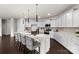 Bright kitchen featuring a large island with barstools, white cabinets, and modern lighting fixtures at 14407 Cardwell Hill Ln, Charlotte, NC 28278
