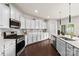 Well-equipped kitchen with stainless steel appliances, sleek white cabinets, and ample counter space at 14407 Cardwell Hill Ln, Charlotte, NC 28278