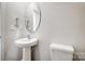 Cozy powder room featuring a pedestal sink, oval mirror, and modern fixtures at 1441 Mccollum St, Monroe, NC 28112