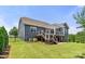 Spacious backyard features a well-maintained lawn and the rear of a home with an inviting deck at 1467 Tranquility Blvd, Lancaster, SC 29720