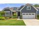 Charming home featuring a manicured lawn, stone accents, gray siding, and an attached two-car garage at 1467 Tranquility Blvd, Lancaster, SC 29720