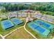 Aerial view of community tennis courts and parking area with trees and the community pool and clubhouse in background at 1467 Tranquility Blvd, Lancaster, SC 29720