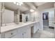 Bathroom features dual sinks, white cabinets, and a large mirror at 14979 Santa Lucia Dr # 2408, Charlotte, NC 28277
