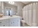 Bright bathroom featuring a white vanity with framed mirror and a shower-tub combination with curtain at 14979 Santa Lucia Dr # 2408, Charlotte, NC 28277