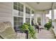 A cozy patio with outdoor seating and lush potted plants near a window and door at 14979 Santa Lucia Dr # 2408, Charlotte, NC 28277