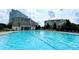A spacious, inviting blue pool offers a relaxing environment with lounge chairs and surrounding buildings at 14979 Santa Lucia Dr # 2408, Charlotte, NC 28277